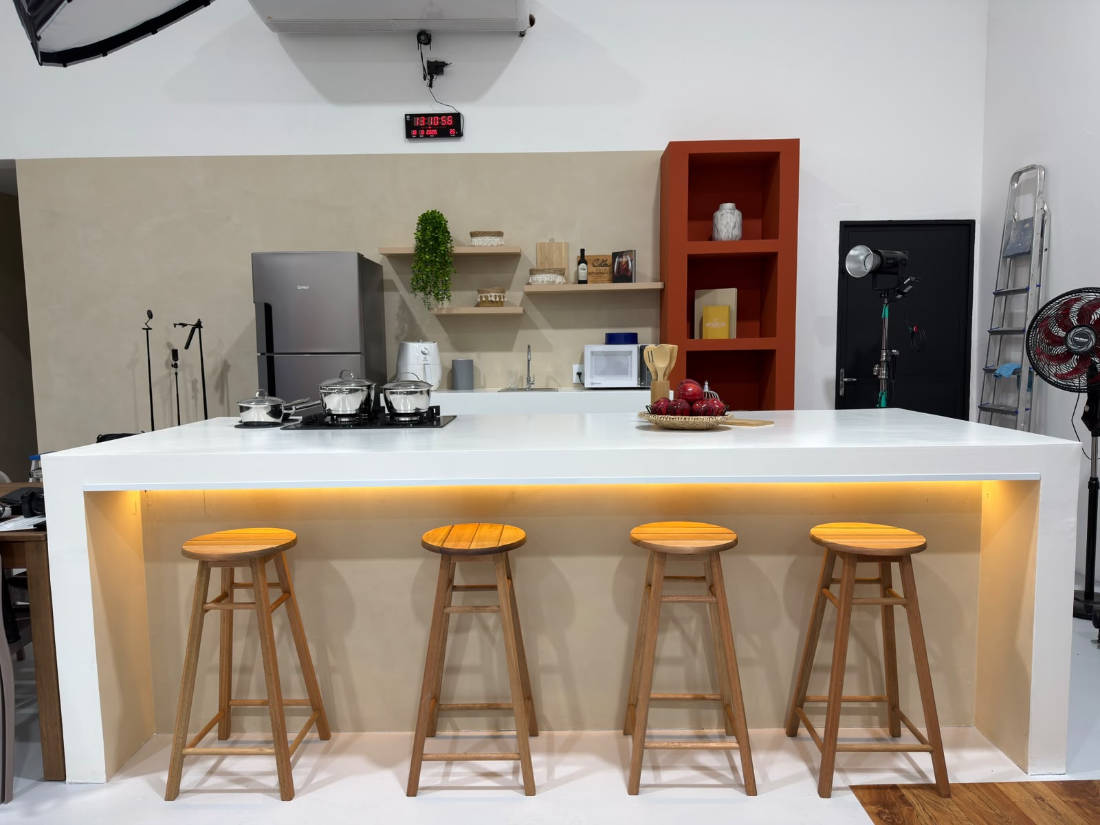 Cozinha funcional do Estúdio 428 com bancada ampla, banquetas de madeira e iluminação profissional