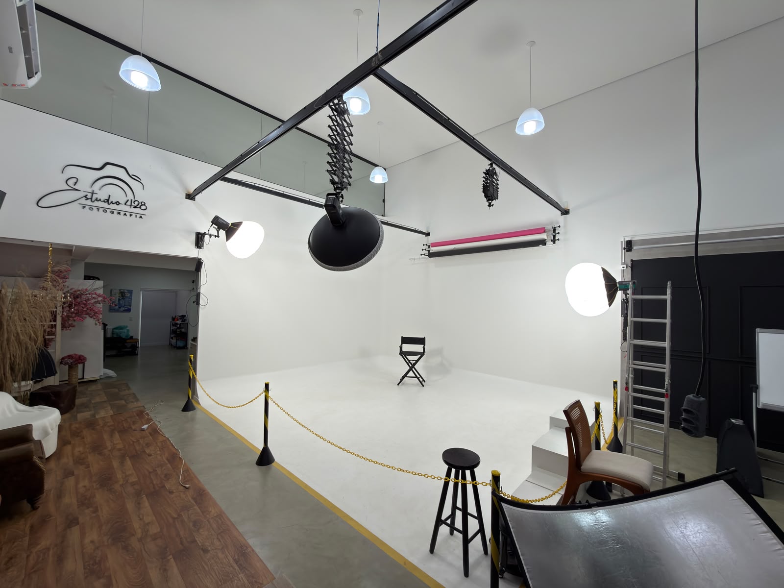 Espaço principal do Estúdio 428 com ciclorama branco infinito, iluminação de teto e equipamentos profissionais